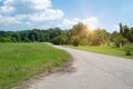 Sunset over the road. Sunrise  in summer beautiful park. Bright sunny day in park. The sun rays illuminate green grass and trees. Royalty Free Stock Photo