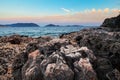 Sunset over rough volcanic rock coastline landscape