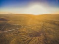 Sunset over rural highway passing through desert landscape. Royalty Free Stock Photo