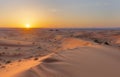 Sunset over the sand dunes in the desert. Arid landscape of the Sahara desert Royalty Free Stock Photo