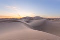 Sunset over the sand dunes in the desert. Arid landscape of the Sahara desert Royalty Free Stock Photo