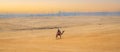 Sunset over the sand dunes in the desert. man riding on camel in desert. Egyptian Camels in the desert. Arabian people traveling Royalty Free Stock Photo