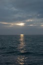 The sun broke through the clouds. Sunset over the sea on a cloudy day. Royalty Free Stock Photo