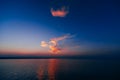 Sunset over sea with blue sky and clouds reflected in water Royalty Free Stock Photo