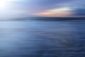 Sunset over the sea. Colorful blue skyline with clouds with smooth wave water flow on the beach. Beautiful sunset sky background.