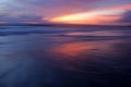 Sunset over the sea. Colorful sunset skyline with clouds with smooth wave water flow on the beach. Beautiful sunset sky background Royalty Free Stock Photo