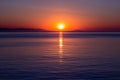 Sunset over sea horizon. Bright sun is reflected from water surface, evening sky Royalty Free Stock Photo