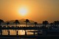 Sunset over the sea with mountains and palm trees