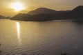 Sunset over the sea. Reflection of the solar track on the surface of the sea. On the horizon - the mountains. Royalty Free Stock Photo