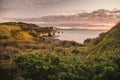 Sunset over sea shore rocks and mount Taranaki, New Zealand