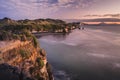 Sunset over sea shore rocks and mount Taranaki, New Zealand