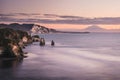 Sunset over sea shore rocks and mount Taranaki, New Zealand