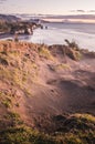 Sunset over sea shore rocks and mount Taranaki, New Zealand