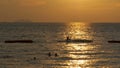 Sunset over the sea and the silhouette of a man fishing on the displacer. Pattaya, Thailand