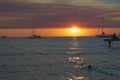 Sunset over the sea with silhouettes of anchored sailboats