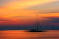 Sunset over a sea with a single yacht