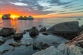 Sunset over sea and stone shore