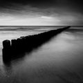 Sunset over the sea with a wooden pier, black and white photo Royalty Free Stock Photo