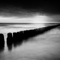 Sunset over the sea with a wooden pier, black and white photo Royalty Free Stock Photo