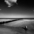 Sunset over the sea with a wooden pier, black and white photo Royalty Free Stock Photo