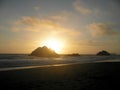 Sunset over Seal rock and Pacific ocean with large cargo ship in the background on Ocean Beach Royalty Free Stock Photo