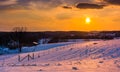 Sunset over snow-covered rolling hills and farm fields in Carroll County, Maryland. Royalty Free Stock Photo