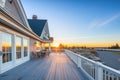 sunset over stone foundation shingle home with large balcony Royalty Free Stock Photo