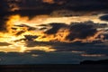 Sunset over stormy clouds across the water reflecting dark and looming dramatic sky moody Royalty Free Stock Photo