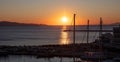 Sunset over Tinos island Cyclades Greece. Ship mast silhouette, port, golden sun colors sky and sea