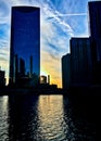 Sunset over a tower along the Chicago River as seen from the Riverwalk during winter. Royalty Free Stock Photo