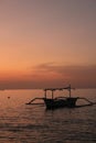 Sunset over the tranquil sea, with silhouette of boat on horizon. North Bali Indonesia. Royalty Free Stock Photo