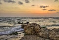 Sunset over tremble sea waves, with rocky seashore, israel