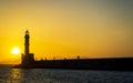 Sunset over The Venetian era harbour walls and lighthouse at the Mediterranean port of Chania Royalty Free Stock Photo