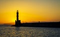 Sunset over The Venetian era harbour walls and lighthouse at the Mediterranean port of Chania Royalty Free Stock Photo