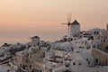 Sunset over white windmills in town of Oia and panorama to Santorini island, Thira, Greece Royalty Free Stock Photo