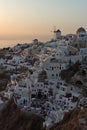 Sunset over white windmills in town of Oia and panorama to Santorini island, Thira, Greece Royalty Free Stock Photo