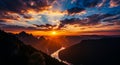 Sunset over a winding river valley with dramatic sun rays piercing through dark clouds and silhouetted mountains Royalty Free Stock Photo