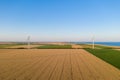 Sunset over the windmills. Wind turbines over fields of wheat and sunflowers Royalty Free Stock Photo