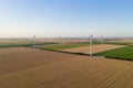 Sunset over the windmills. Wind turbines over fields of wheat and sunflowers Royalty Free Stock Photo