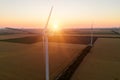 Sunset over the windmills. Wind turbines over fields of wheat and sunflowers Royalty Free Stock Photo