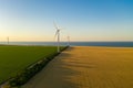 Sunset over the windmills. Wind turbines over fields of wheat and sunflowers Royalty Free Stock Photo