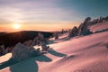 Sunset over the winter landscape from the top of a snowy hill. Royalty Free Stock Photo