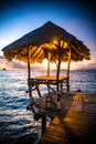 Sunset over wooden beach bar in sea and hut on pier in koh Mak island, Trat, Thailand Royalty Free Stock Photo