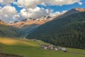 Sunset panorama of alpine valley with village and mountains with glaciers Royalty Free Stock Photo