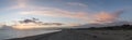 Sunset panorama over shingle beach with colorful vibrant sky and Royalty Free Stock Photo