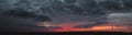 sunset panorama with raspberry clouds over a small town Royalty Free Stock Photo
