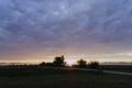 Sunset in the park near the river. Field and bench in the foreground, the silhouette of trees and mountains in the background Royalty Free Stock Photo