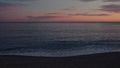 Sunset on pebble beach with sea waves of mediterranean sea