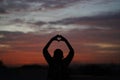 Sunset Picture With a Small African Boy Raising His Hands To Heaven Forming The Heart Love Symbol