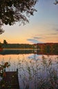 Sunset at the pier with house and forest in the background Royalty Free Stock Photo